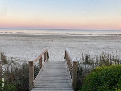 wooden walkway to the beach at sunset photo