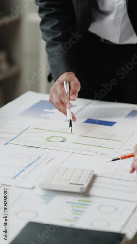 Vertical footage of Close up of hands teamwork business group are meeting working calculate and brainstorming about business financial and marketing on paperwork and presentation. photo