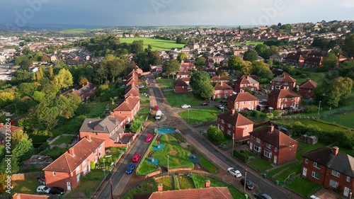 Yorkshire's housing district: Red-brick council housing, aerial view, sunny morning, residents going about their day.