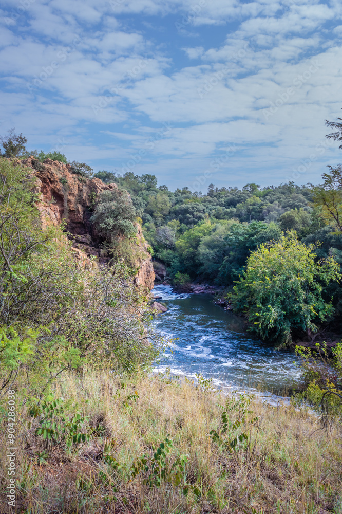 View of a Hennops Hiking Trail, with river running through, small bridge and cableway over the river, Hartbeespoort, Johannesburg, South Africa View of a Hennops Hiking Trail, with river running through, small bridge and cableway over the river, Hartbeespoort, Johannesburg, South Africa