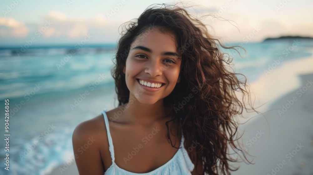 Portrait of young woman at sea looking at camera. Smiling latin hispanic girl standing at the beach with copy space and look Portrait of young woman at sea looking at camera. Smiling latin hispanic girl standing at the beach with copy space and look