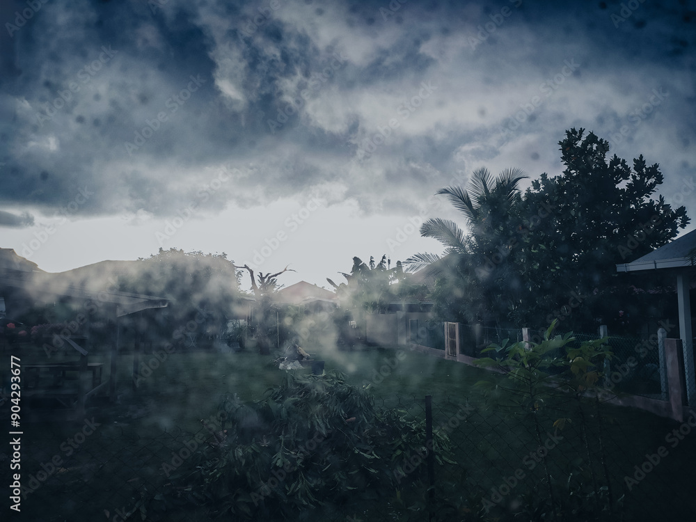 Captured from inside a house during heavy rain season, this image showcases dew drops on the window, creating a beautiful, misty view of the rainy season outside. heavy rain in Kuantan, Malaysia Captured from inside a house during heavy rain season, this image showcases dew drops on the window, creating a beautiful, misty view of the rainy season outside. heavy rain in Kuantan, Malaysia