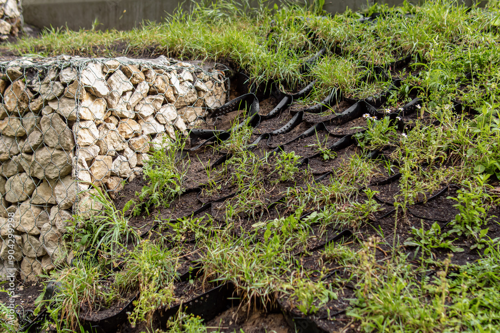 Gabion fence and black geogrid. Strengthening the slope. Natural Gabion fence and black geogrid. Strengthening the slope. Natural