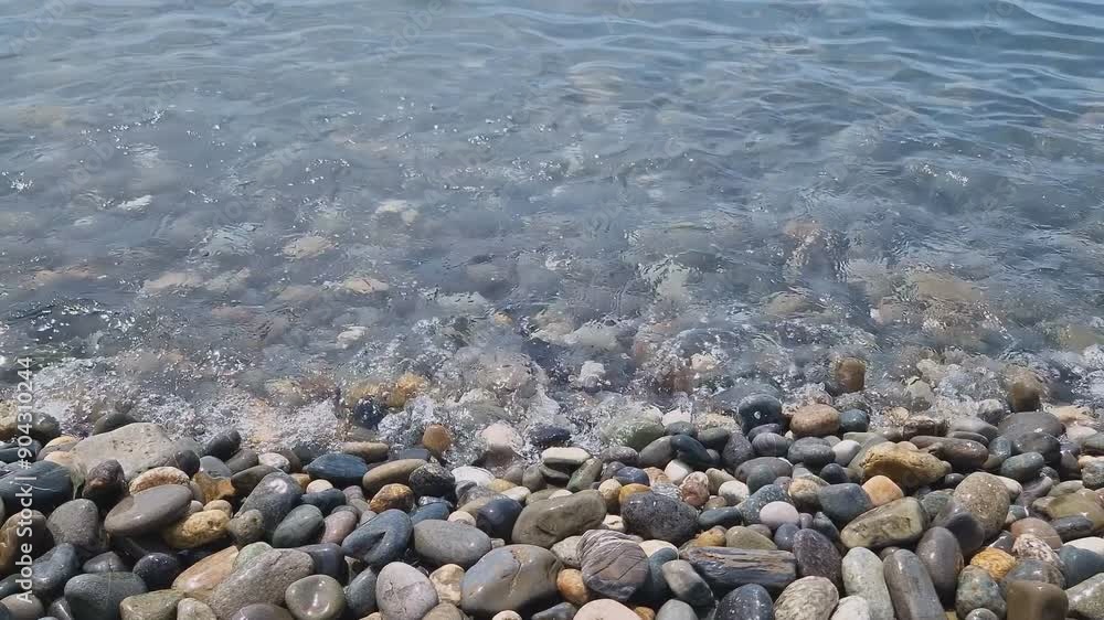 Waves break on the rocks on the beach, sea spray, sunlight is reflected in the water. Waves break on the rocks on the beach, sea spray, sunlight is reflected in the water.