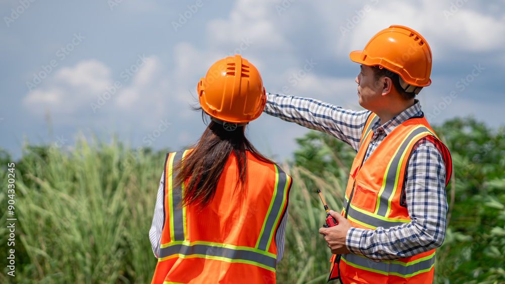 Survey team is working with a theodolite and road construction plans. Civil engineers are taking measurements with surveying tools during the construction. Survey team is working with a theodolite and road construction plans. Civil engineers are taking measurements with surveying tools during the construction.
