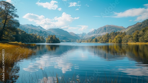 Serene lake surrounded by hills under clear blue sky in tranquil midday light