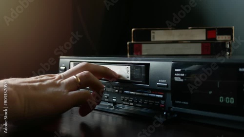 Loading a video cassette into a VCR.