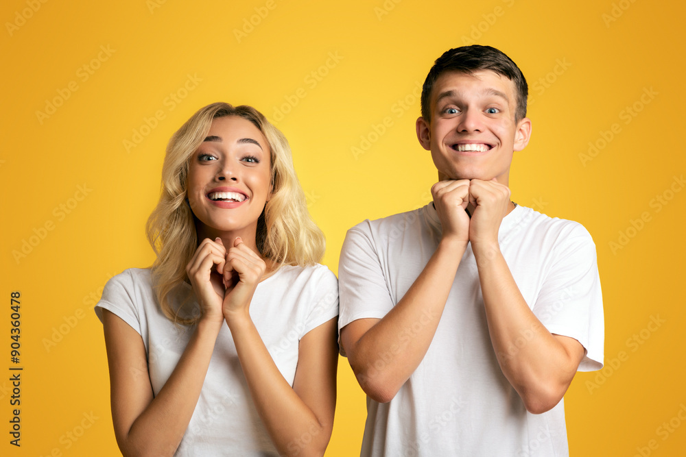 Young Couple Pleading For Something And Keeping Hands Together On Yellow Background, Copy Space Young Couple Pleading For Something And Keeping Hands Together On Yellow Background, Copy Space