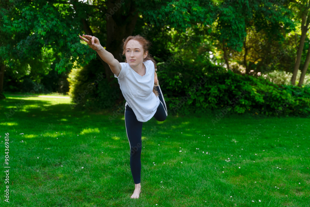 Girl Practicing Balance and Flexibility in a Lush Green Park on a Sunny Day Girl Practicing Balance and Flexibility in a Lush Green Park on a Sunny Day