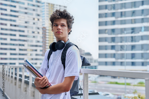 Portrait young male college student with backpack textbooks copybooks, outdoor photo