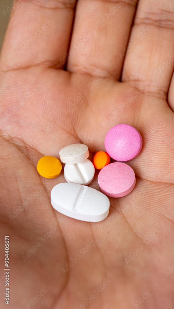 male model holding various health pills in his hand male model holding various health pills in his hand