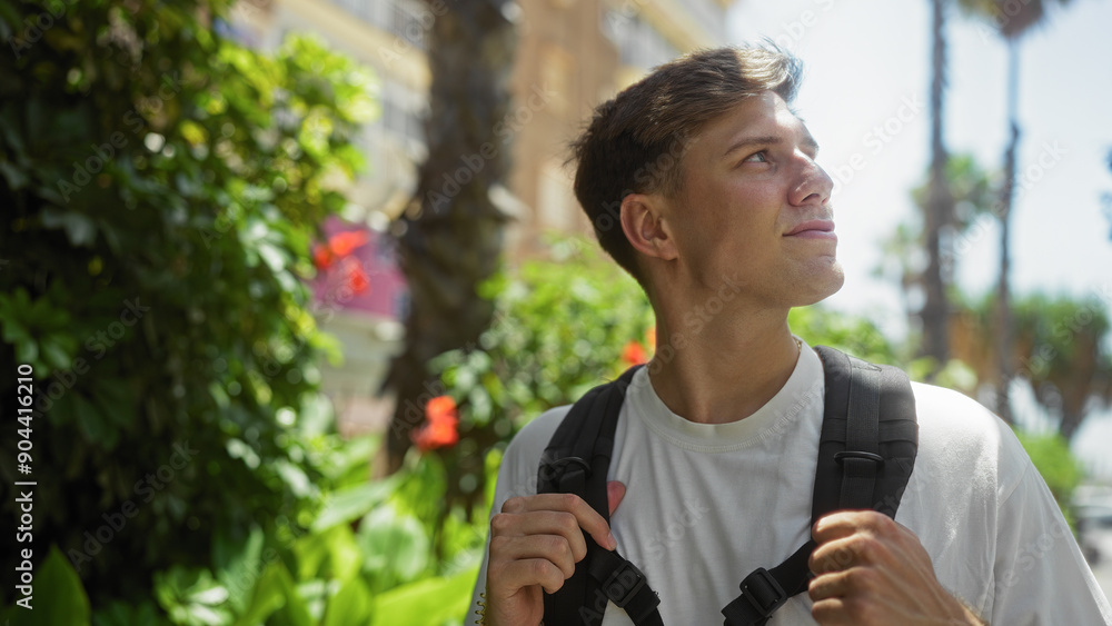 Handsome man walking in urban park with backpack during sunny day Handsome man walking in urban park with backpack during sunny day