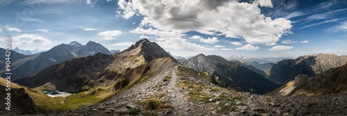 panoramic view of mountains with a path on the ridge ; summer in the ecrins mountain range in the alps