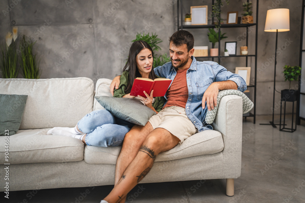 Obraz premium relax couple boyfriend and girlfriend sit on sofa and read a book