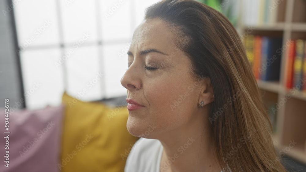 A serene hispanic woman with her eyes closed and a subtle smile, in a cozy room with colorful cushions. A serene hispanic woman with her eyes closed and a subtle smile, in a cozy room with colorful cushions.