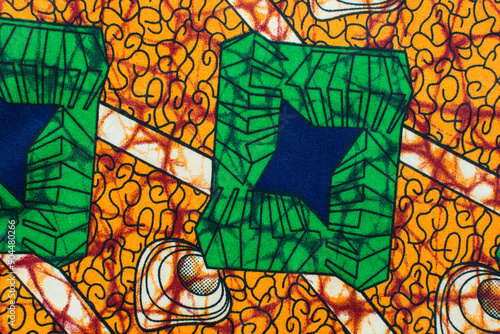 top view of orange ankara fabric, flatlay of nigerian wax cloth with designs, spread out orange ankara material photo