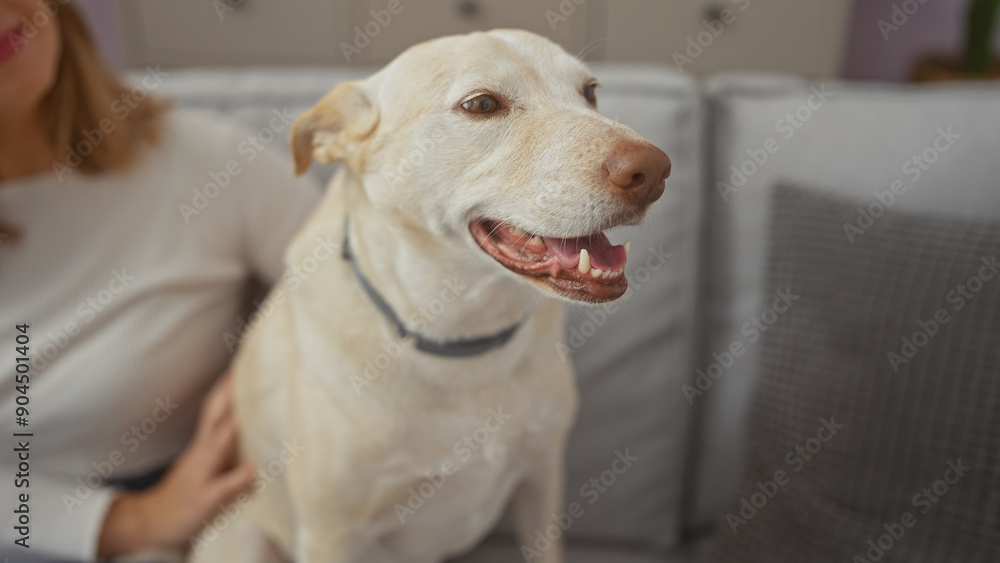 A young adult woman affectionately pets her smiling dog indoors, portraying a warm moment between owner and pet at home.