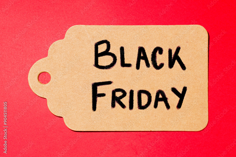 Kraft paper label with the text “Black Friday” handwritten on red background. Shopping and saving. Kraft paper label with the text “Black Friday” handwritten on red background. Shopping and saving.