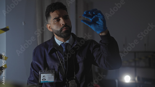 A focused hispanic detective examines evidence at an indoor crime scene with meticulous care and professionalism. photo