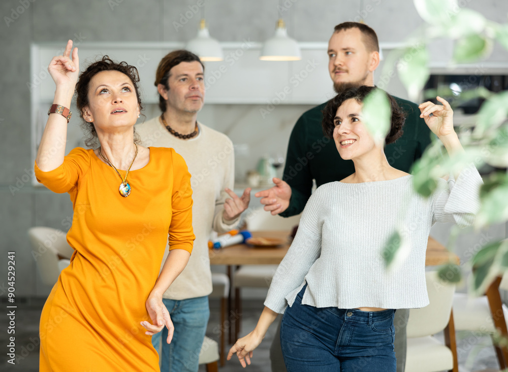 Fototapeta premium Friends dancing. Cheerful young people dancing and drinking while enjoying home party on the room