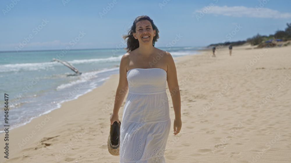 A beautiful young hispanic woman enjoys a sunny day at a serene beach in pescoluse, salento, puglia, italy, wearing a white dress and holding her sandals. A beautiful young hispanic woman enjoys a sunny day at a serene beach in pescoluse, salento, puglia, italy, wearing a white dress and holding her sandals.