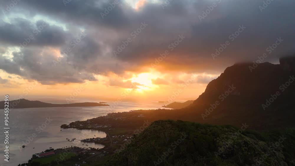 Sunset behind Mount Otemanu on the tropical island of Bora Bora. Aerial footage captured by drone over the mountain surrounded by south pacific ocean water. Sunset behind Mount Otemanu on the tropical island of Bora Bora. Aerial footage captured by drone over the mountain surrounded by south pacific ocean water.