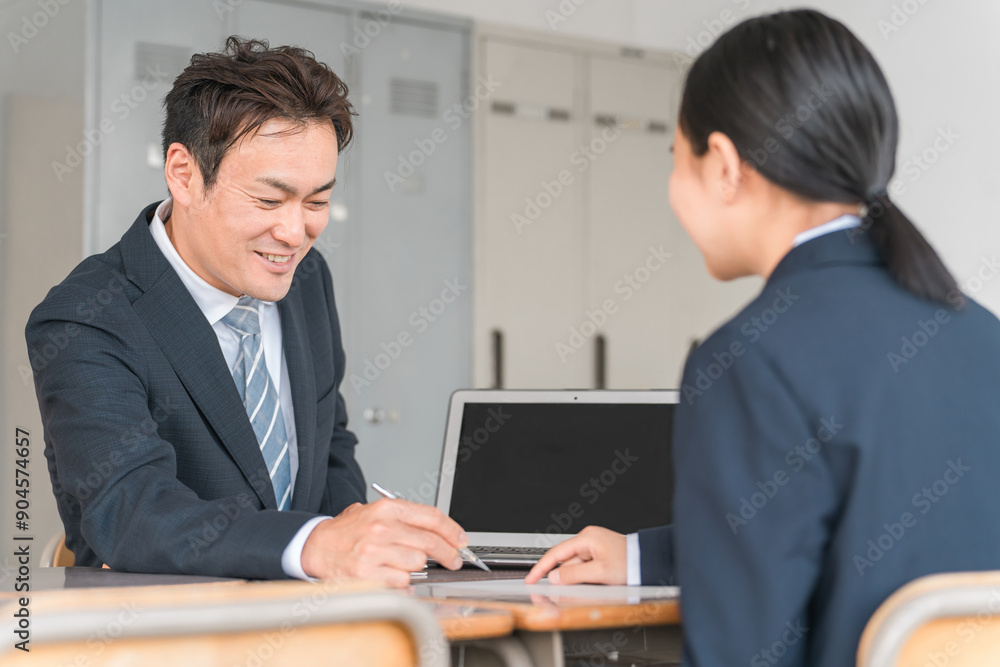 面談・進路相談・二者面談をする男性教師とブレザー姿の女子中学生
面談・進路相談・二者面談をする男性教師とブレザー姿の女子中学生