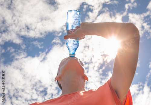 Young female drinking water from bottle on a hot summer day, Dehydrated woman drinks from water bottle replenish fluids 