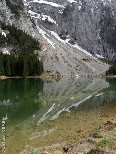 reflection of the mountain cliff with snow in lac Benit in Haute Savoie near Cluses in france photo