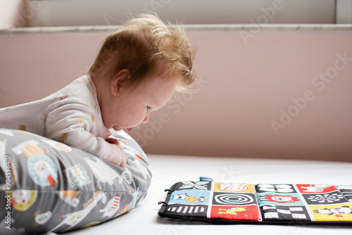 Φωτογραφία Little cute Caucasian baby girl doing tummy time