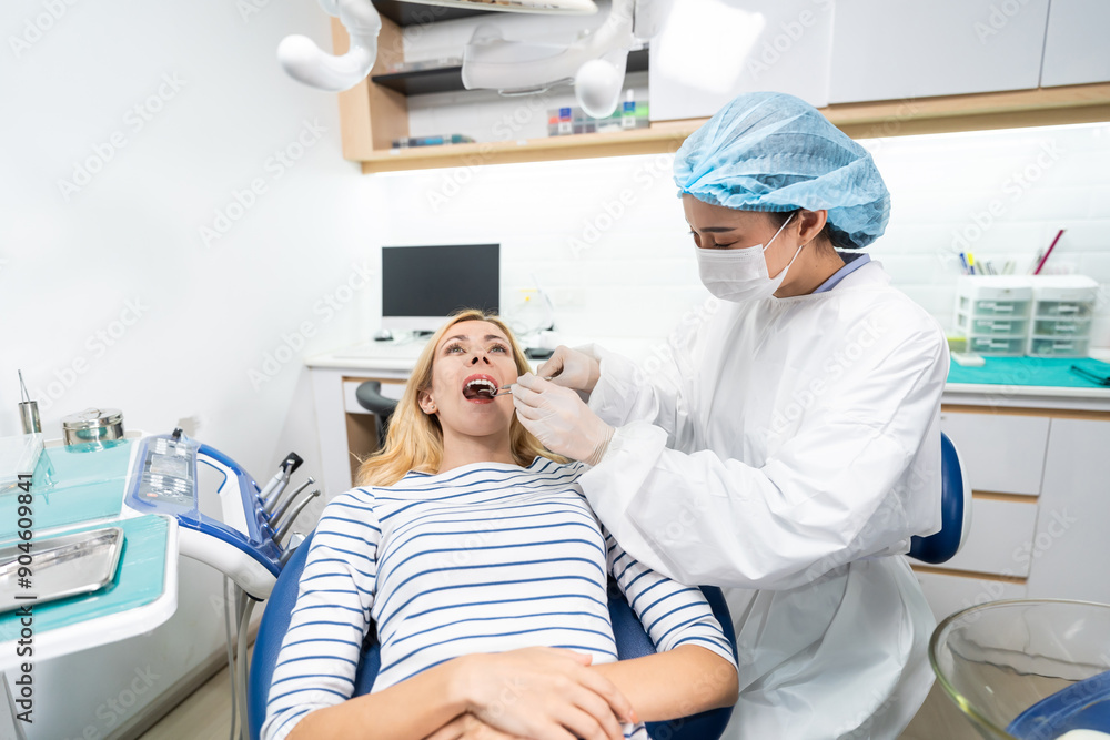 Obraz premium Female dentist examine tooth to Caucasian girl at dental health clinic. 