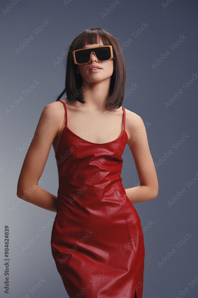 A stylish woman in a red leather dress, wearing sunglasses, confidently poses for the camera, capturing a bold fashion statement with a contemporary edge in a chic urban setting A stylish woman in a red leather dress, wearing sunglasses, confidently poses for the camera, capturing a bold fashion statement with a contemporary edge in a chic urban setting