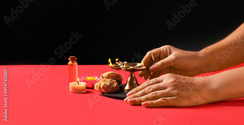 Female hands with diya lamp...