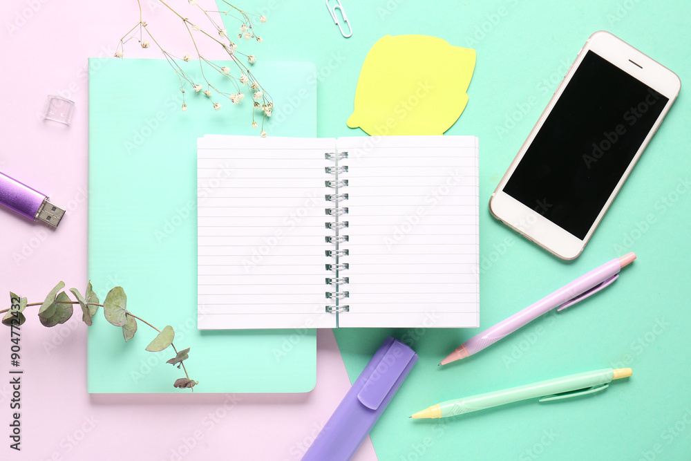 Composition with notebook, mobile phone and pens on colorful background Composition with notebook, mobile phone and pens on colorful background