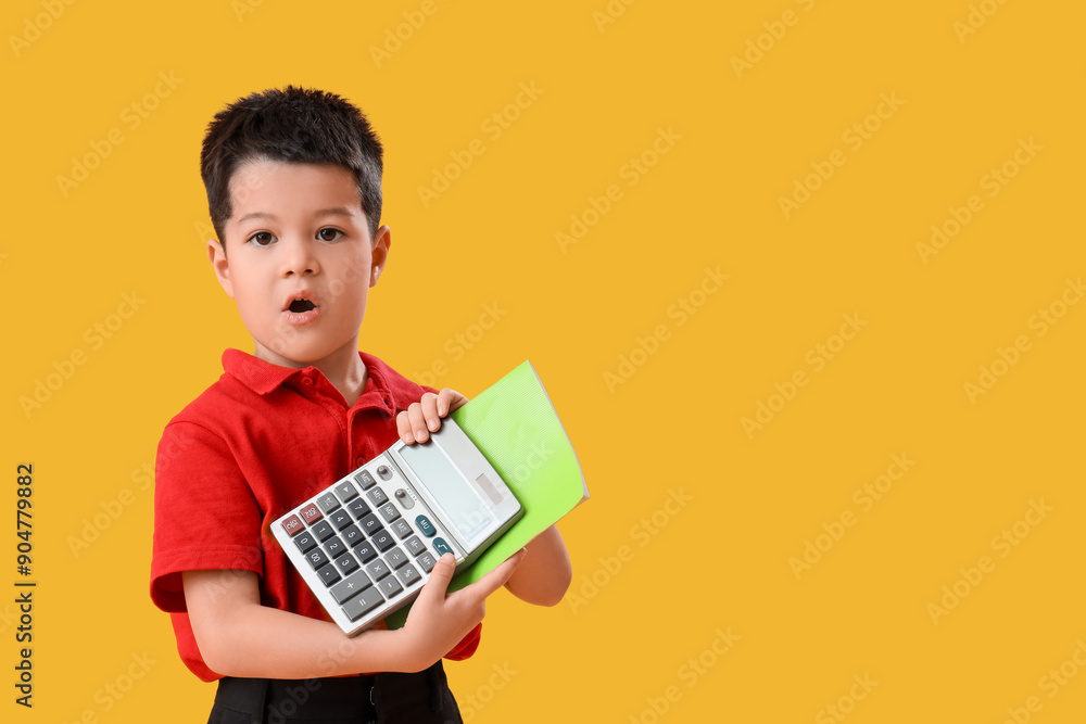 Little school boy with calculator on yellow background Little school boy with calculator on yellow background