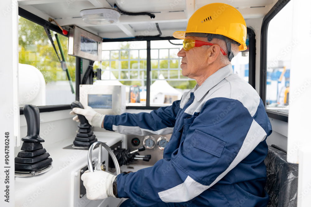 Man driver in uniform operate of excavator truck at construction site Man driver in uniform operate of excavator truck at construction site