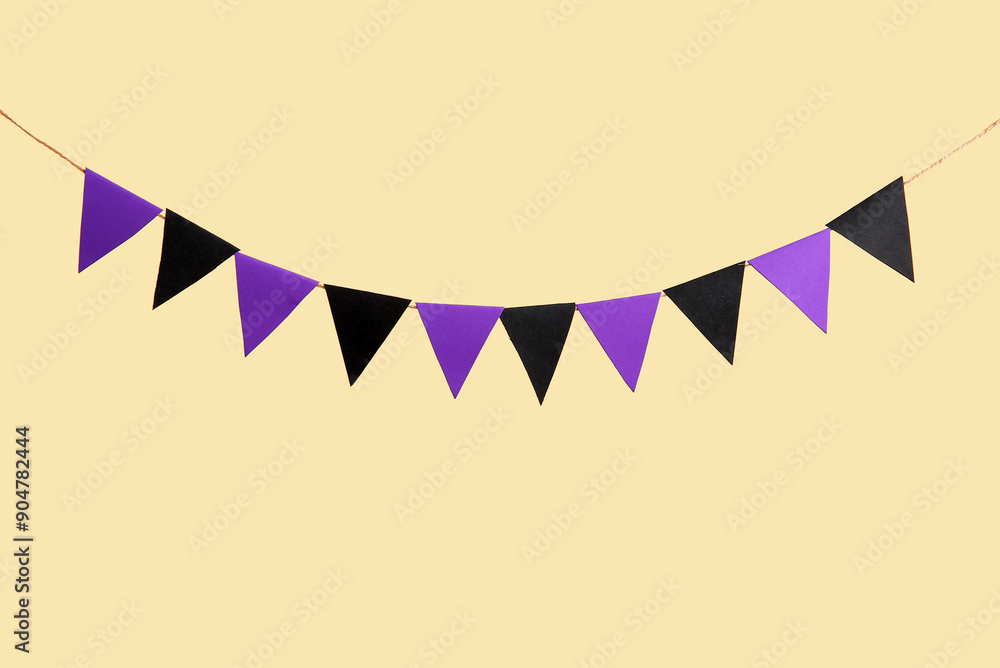 Fototapeta premium Garland made of paper flags for Halloween celebration on beige background