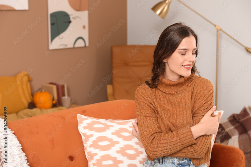 Happy young woman sitting at home on autumn day Happy young woman sitting at home on autumn day