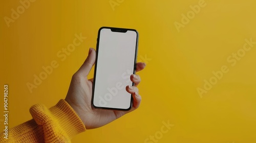 A person is holding a cell phone with a yellow background