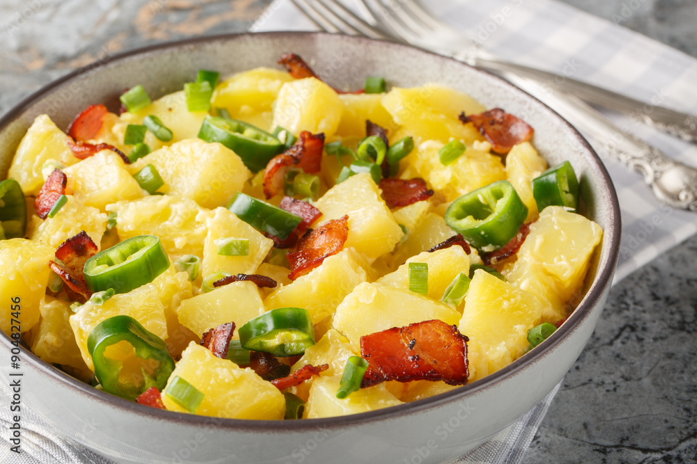 Creamy potato jalapeno salad with bacon, green onions and mayonnaise close-up in a bowl on the table. Horizontal Creamy potato jalapeno salad with bacon, green onions and mayonnaise close-up in a bowl on the table. Horizontal