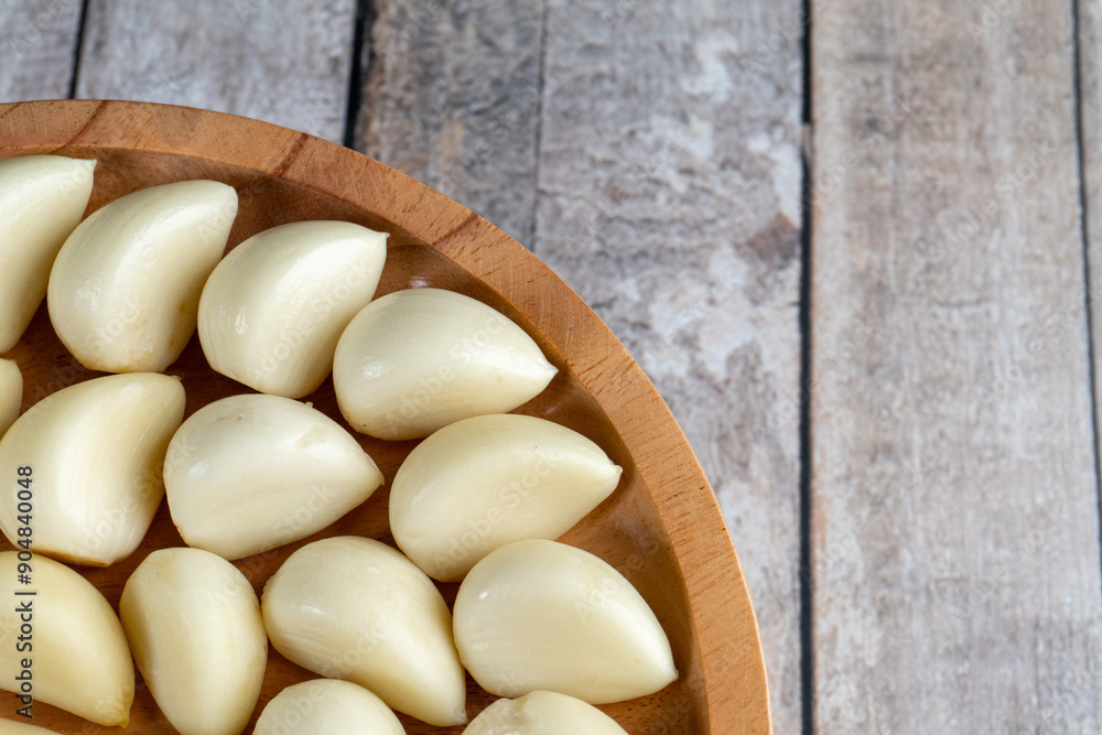 top view close up of half wooden plate filled with arranged of garlic top view close up of half wooden plate filled with arranged of garlic