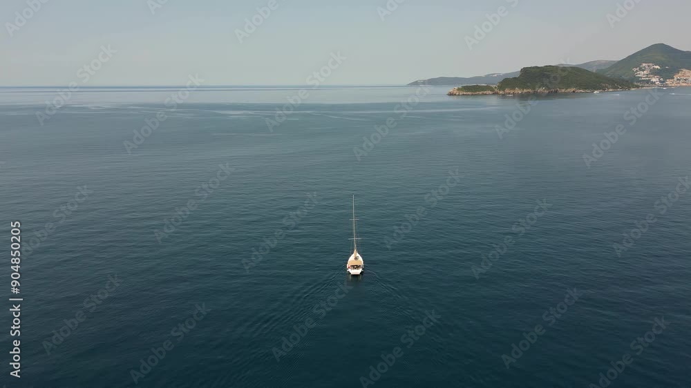 Aerial view of a white yacht sailing in the open sea Aerial view of a white yacht sailing in the open sea