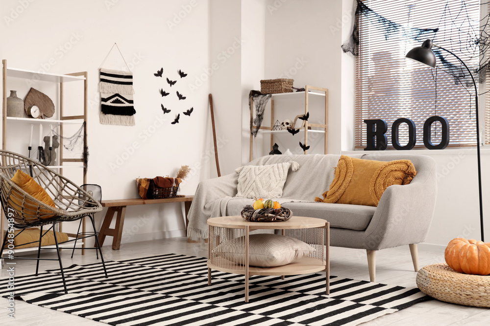 Fototapeta premium Interior of living room decorated for Halloween with grey sofa and armchair