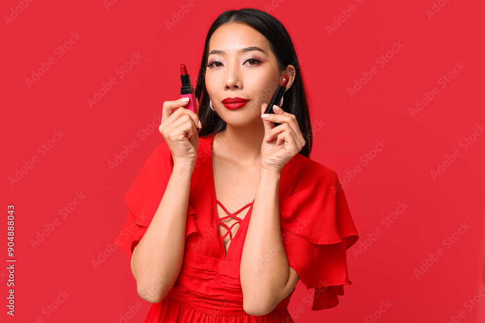Portrait of beautiful Asian woman with lipsticks on red background Portrait of beautiful Asian woman with lipsticks on red background