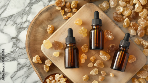 A frankincense essential oil bottle and resin on a wooden table photo