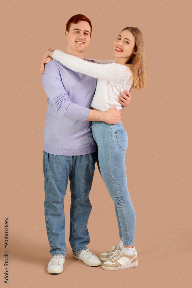 Happy young couple hugging on brown background Happy young couple hugging on brown background