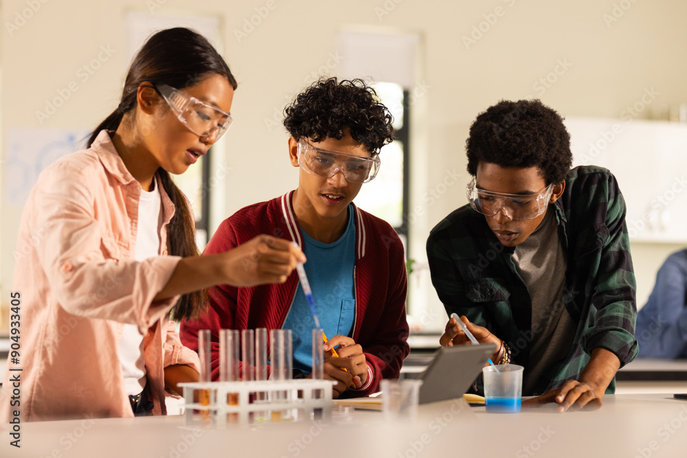 Conducting science experiment with test tubes and safety goggles, teenagers in high school Conducting science experiment with test tubes and safety goggles, teenagers in high school