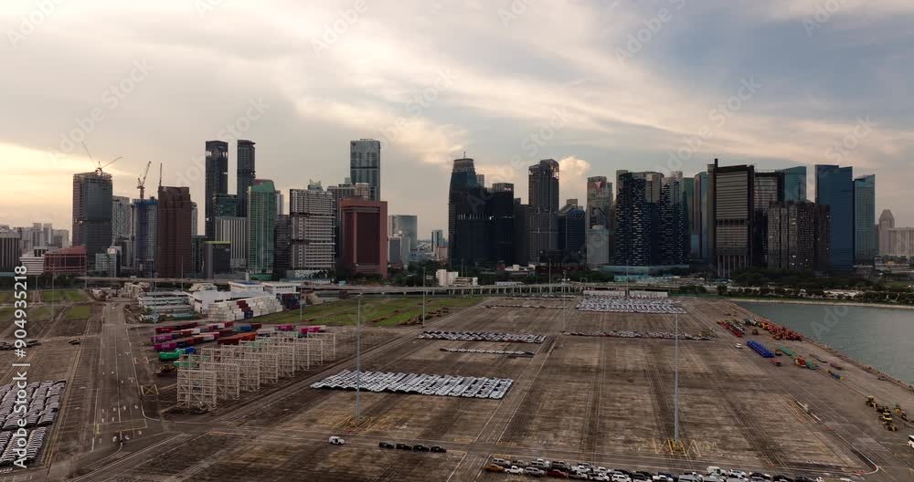 Fleet of cars parked on big Singapore port terminal with skyline view, drone Fleet of cars parked on big Singapore port terminal with skyline view, drone