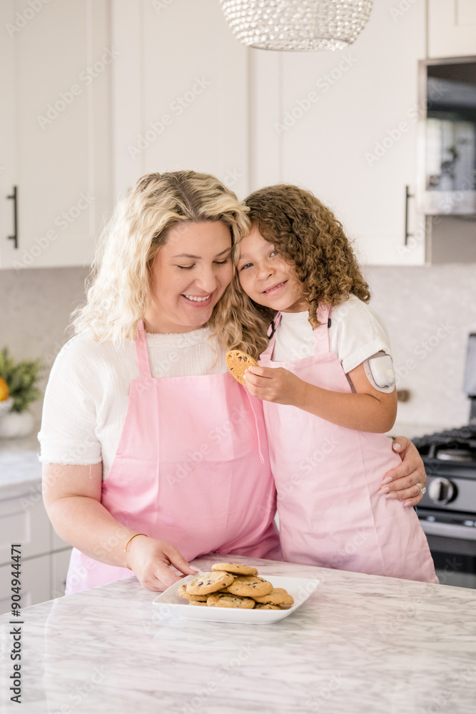 Mother holding daughter while daughter is holding a cookie Mother holding daughter while daughter is holding a cookie