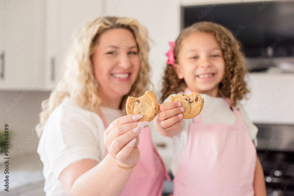 Close up of Mother and daughter holding a cookies smiling Close up of Mother and daughter holding a cookies smiling